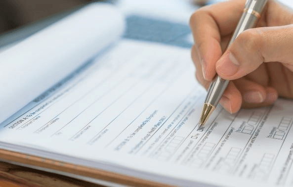 Hand writing on a project document with a pen